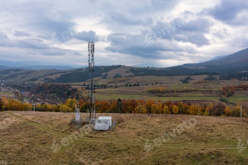 Preview: Cell tower near mountain settlement under gloomy sky