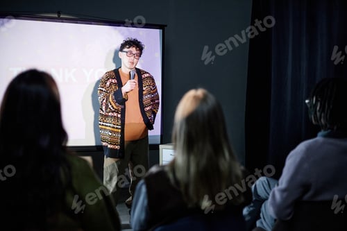 Preview: Young Adult Man Giving Presentation to Diverse Audience Indoors