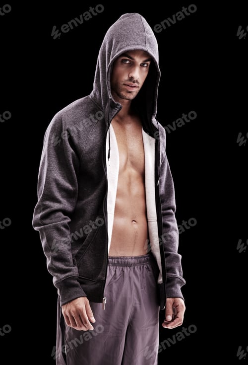 Preview: Brooding manliness. Studio shot of a brooding bare-chested young man wearing a hoodie.