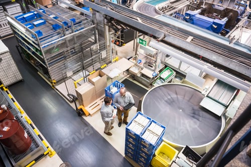Preview: Top view of two men talking in factory shop floor
