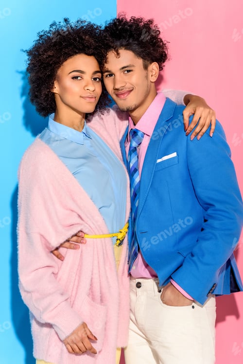 Preview: fashionable young couple hugging each other on pink and blue background