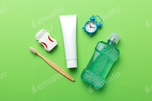 Preview: Mouthwash and other oral hygiene products on colored table top view with copy space. Flat lay.
