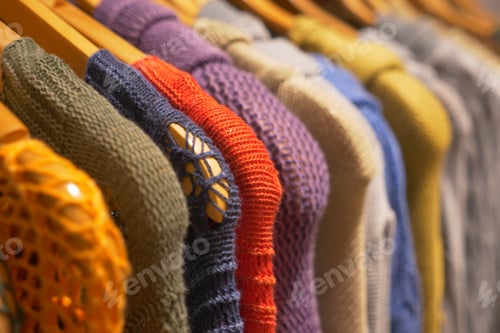 Preview: A Collection of Vibrant and Colorful Knit Sweaters Beautifully Displayed on Hangers