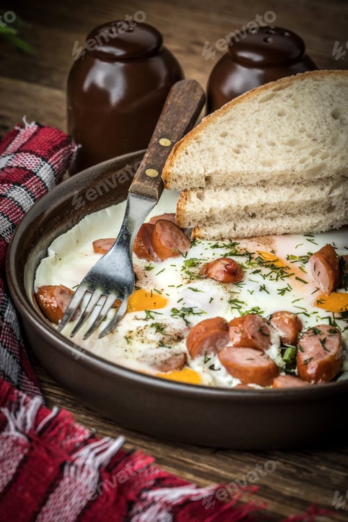 Preview: Tasty cooked egg with chopped sausages.