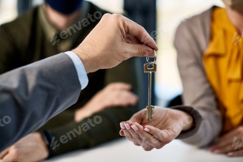 Preview: Close-up of couple receiving key from real estate agent while buying a new home