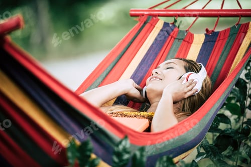 Preview: Woman relaxes in colorful hammock listening to music