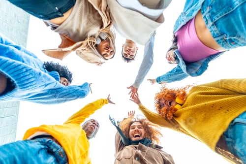Preview: Smiling multi-ethnic group join and raising hands