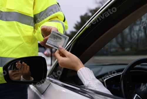 Preview: Woman giving bribe to police officer out of car window, closeup