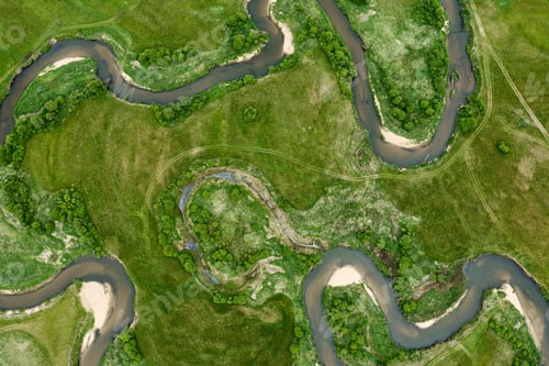 Preview: Aerial view of the river surrounded by green trees and grass