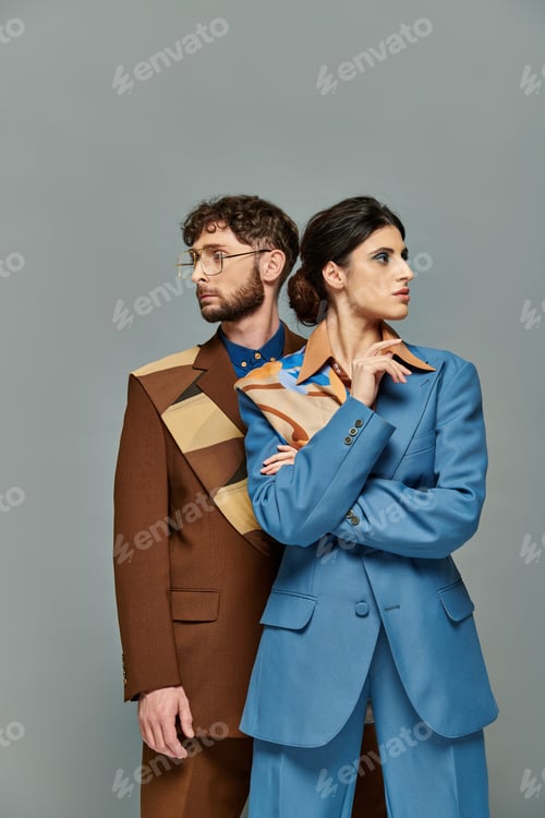 Preview: portrait of man in glasses and woman looking at different directions, models in trendy suits