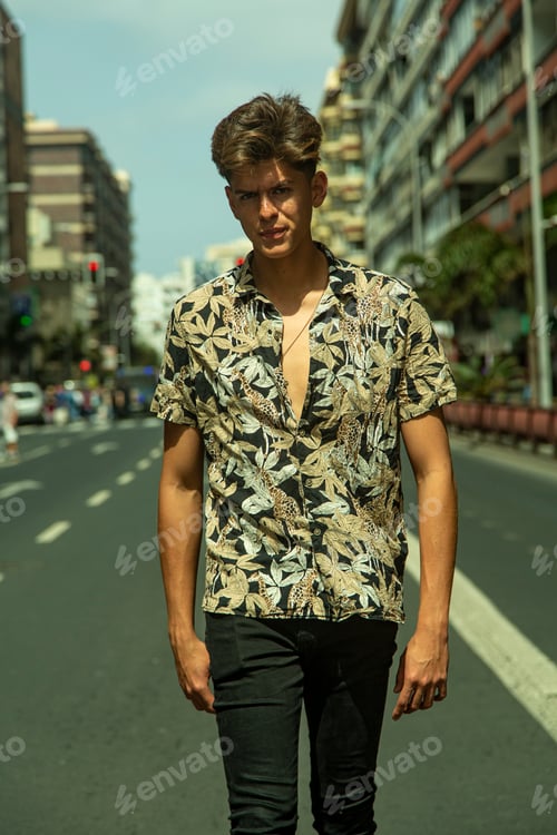 Preview: Young man with tough guy face walking in the middle of the street.