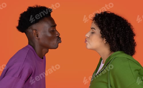 Preview: Closeup of interracial couple kissing on red, copy space