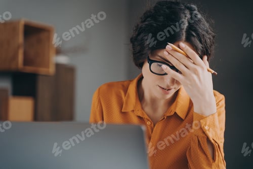 Preview: Frustrated tired young Spanish woman office worker in glasses covering face with hand