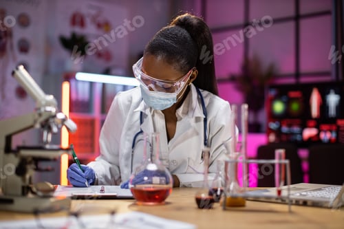Preview: woman microbiologist or medical worker writing research results in the laboratory.