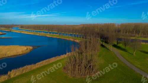 Preview: Scenic waterway with lush greenery and trees on a sunny day