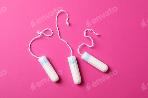 Preview: Three tampons on pink background, top view