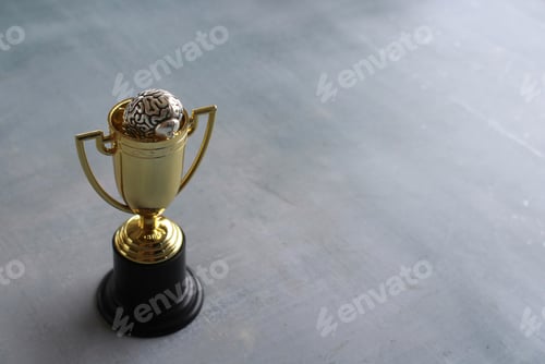 Preview: Brain inside gold cup trophy with copy space.