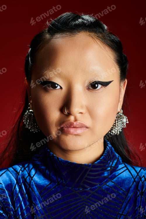 Preview: A striking portrait of an elegant Asian woman showcasing bold makeup against a vibrant backdrop