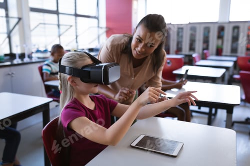 Preview: African american female teacher teaching caucasian girl to use vr headset in the class at school