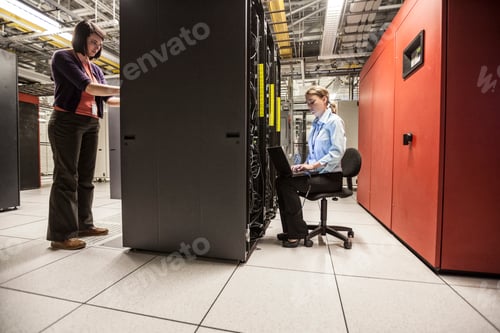 Preview: Caucasian women technicians working on computer servers in a server farm.