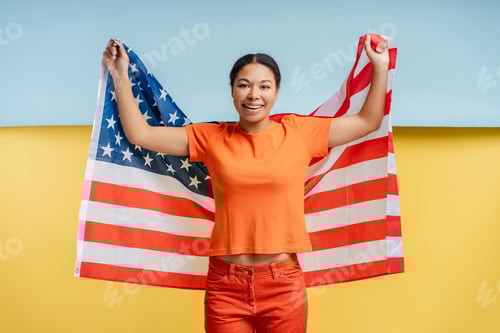 Preview: Young Woman Smiling Holding American Flag in Studio