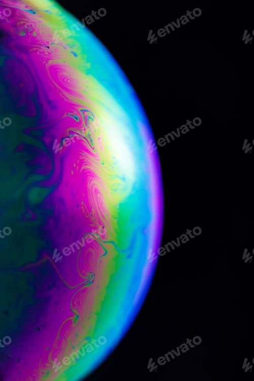 Preview: Rainbow soap bubble on a black background. Close-up of a colorful surface.