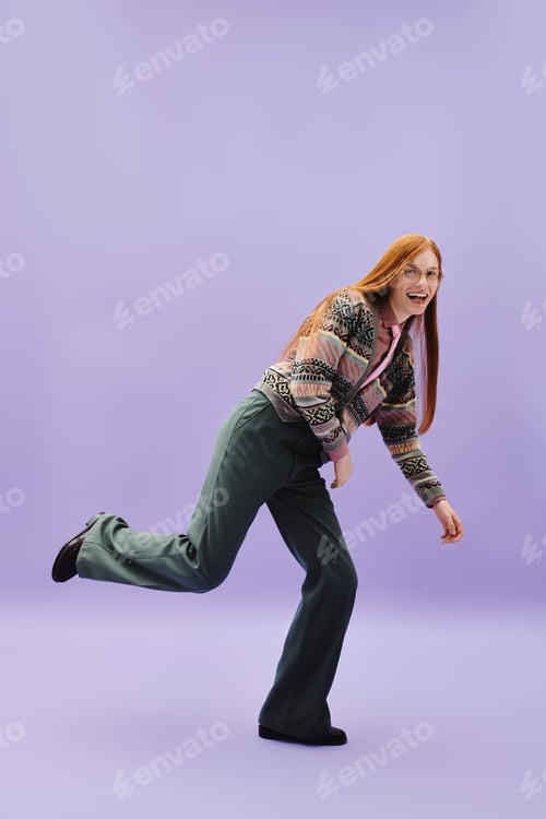 Preview: Stylish young man playfully striking a pose against a vibrant purple backdrop