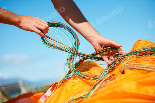 Preview: Prepared for a day of paragliding. Closeup shot of a man preparing his paragliding equipment.