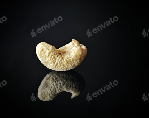 Preview: a single peeled banana on a shiny black surface with water and a reflection
