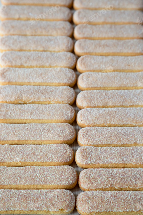 Preview: Savoiardi or ladyfingers cookies on a white wooden background, side view.