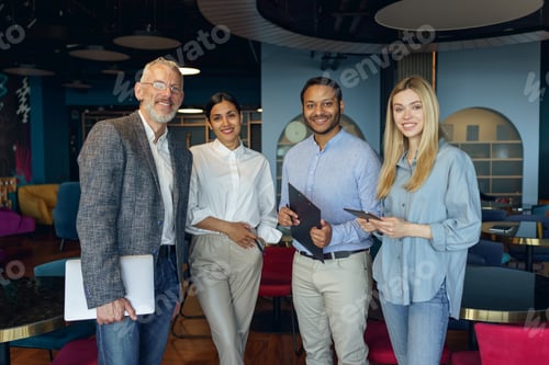 Preview: Group of diverse business people standing on office background and looking on camera