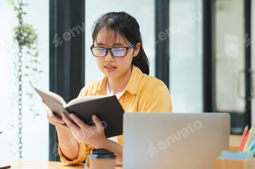 Preview: Serious young asian student reading a book preparing the exam.