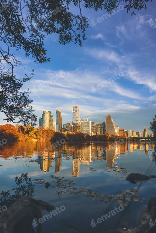 Preview: The Austin city skyline is reflected in Lady Bird Lake under a vibrant blue sky.