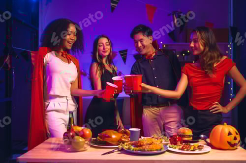 Preview: Asian friends, middle-aged man and young woman, enjoy Halloween office party with vampire costumes