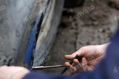 Preview: Male hand repair old car. Auto mechanic working on car engine in mechanics garage. Automotive mechan