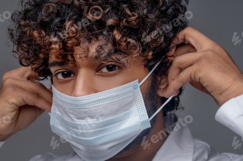 Preview: Male physician in a lab coat preparing for work