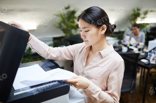 Preview: Asian Businesswoman Printing Documents in Office