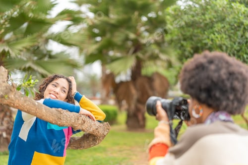 Preview: Woman posing while being photographed by her friend with a camera