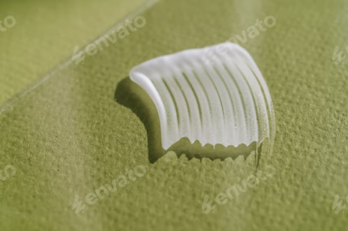Preview: White cream texture on a green background.