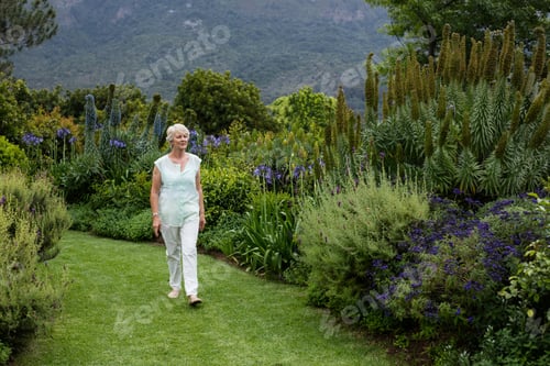 Preview: Woman Strolling Through Lush Botanical Garden