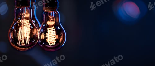 Preview: A burning lamps hangs in the dark on a blurred background. Space for text.