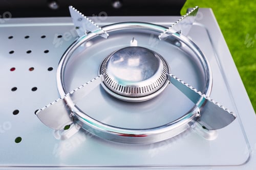 Preview: Detail of the gas burner of a kitchen, clean and new in steel.