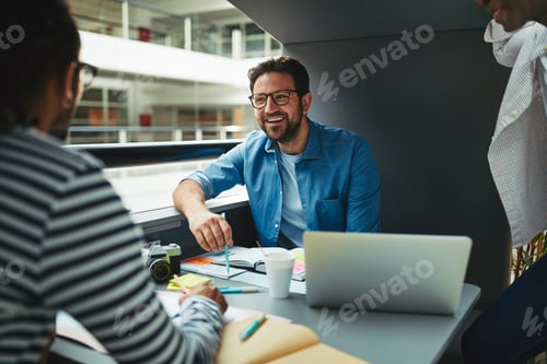 Preview: Three laughing designers working in an office meeting pod