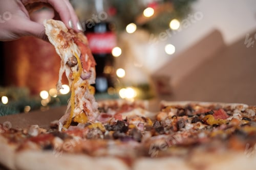 Preview: Female hand holding yummy slice of pizza