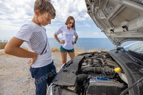 Preview: Teenage boy with his mother trying to fix broken rent car during summer vacation.