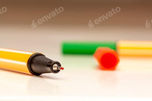 Preview: Closeup shot of a white-yellow stripes pen on a blurred background