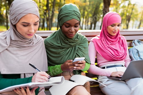 Preview: Modern Muslim Females Students Learning Using Phone And Laptop Outdoors