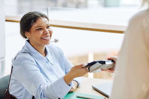 Preview: Smiling Woman using Credit Card in Cafe