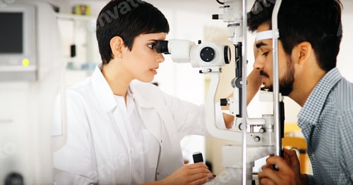 Preview: Woman doing eye test with optometrist in eye sight clinic