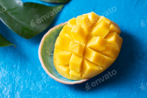 Preview: Mango slice on blue background, tropical concept